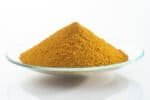Yellow iron oxide pigment on a clear glass dish for industrial use.