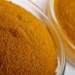 Close-up of yellow iron oxide pigment in glass containers.