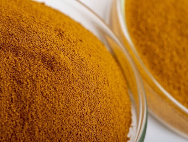 Close-up of yellow iron oxide pigment in glass containers.
